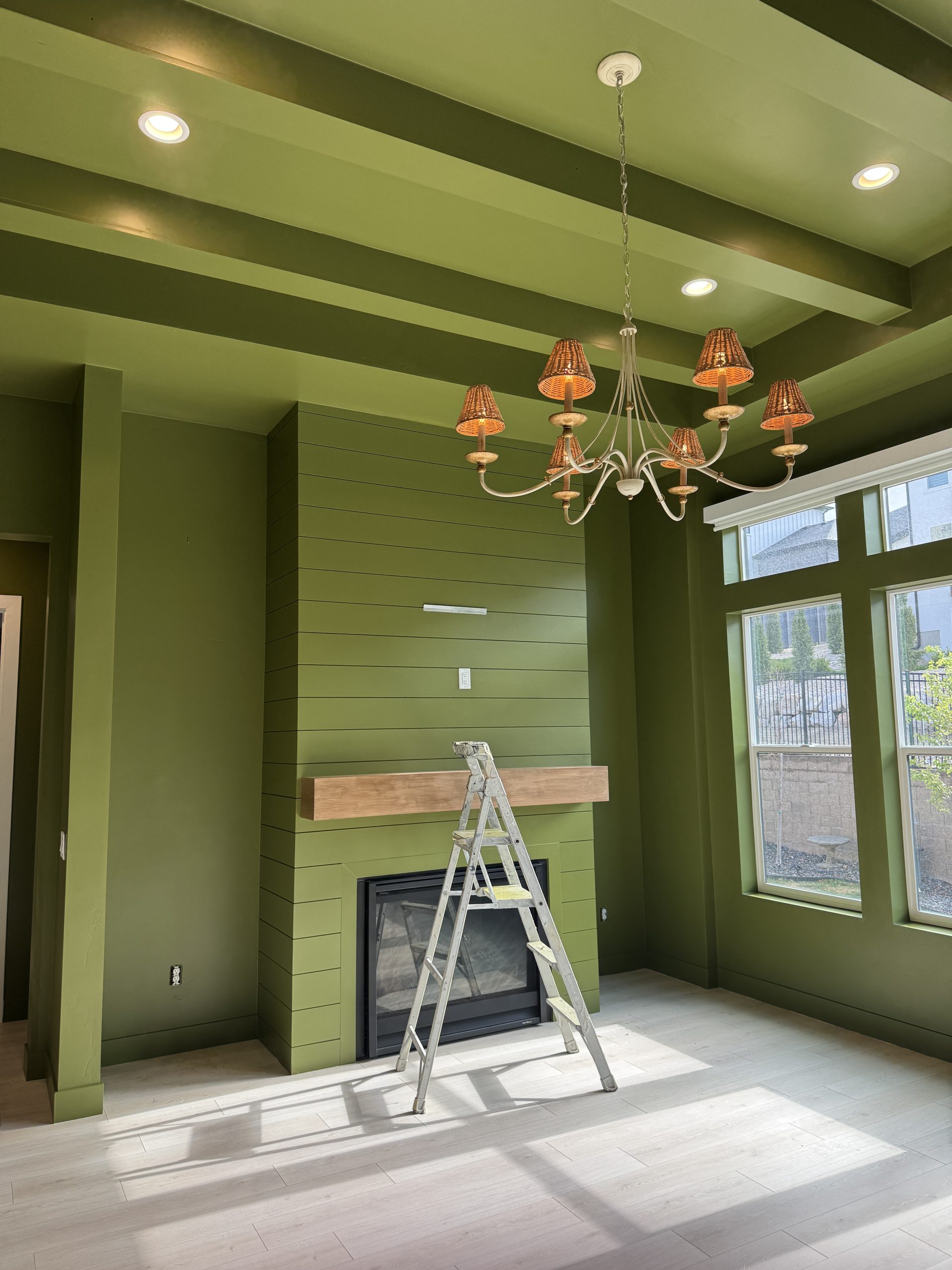 Moss green great room with painted shiplap fireplace and coffered ceiling